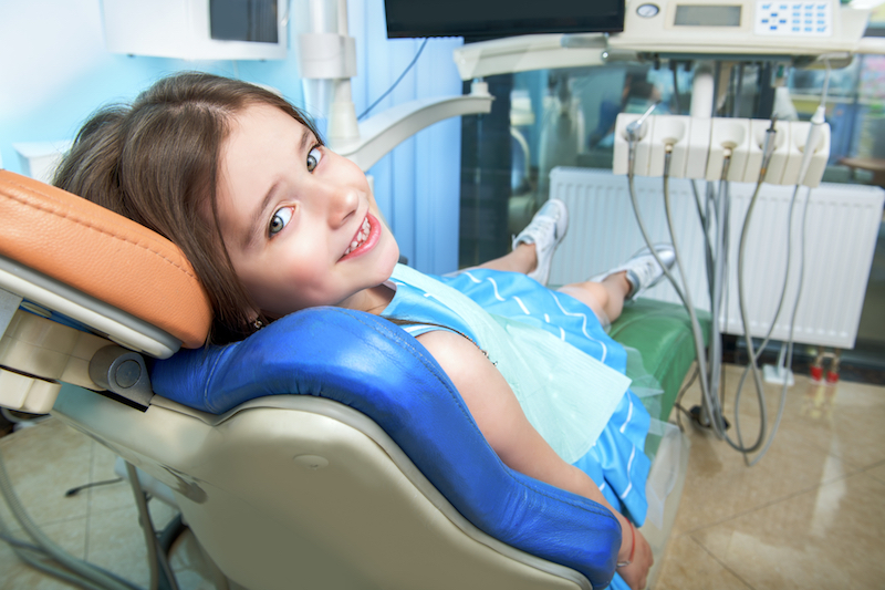 child at dentist's office in dental chair