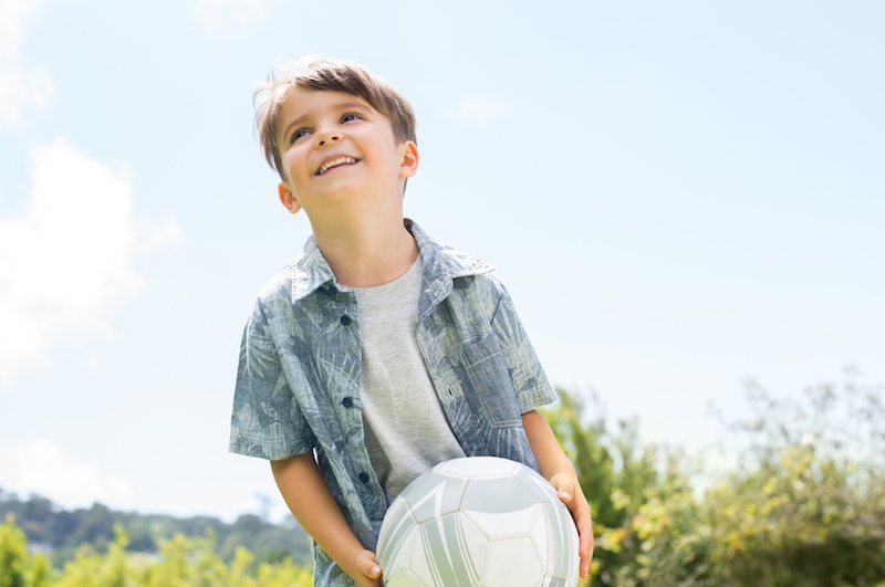 Boy with soccer ball smiling